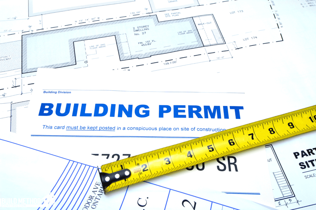 A building permit with a tape measure on top of it.