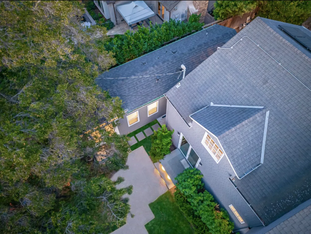 An aerial view of a house with trees in the background.